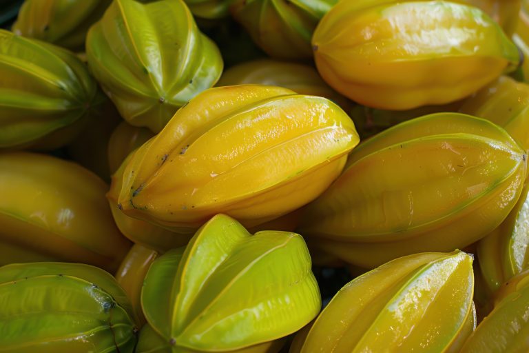 A fruit called Starfruit oval shaped with yellow skin and flesh typically with five ridges